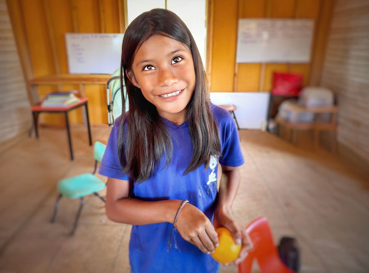 A smiling girl holding fresh fruit
